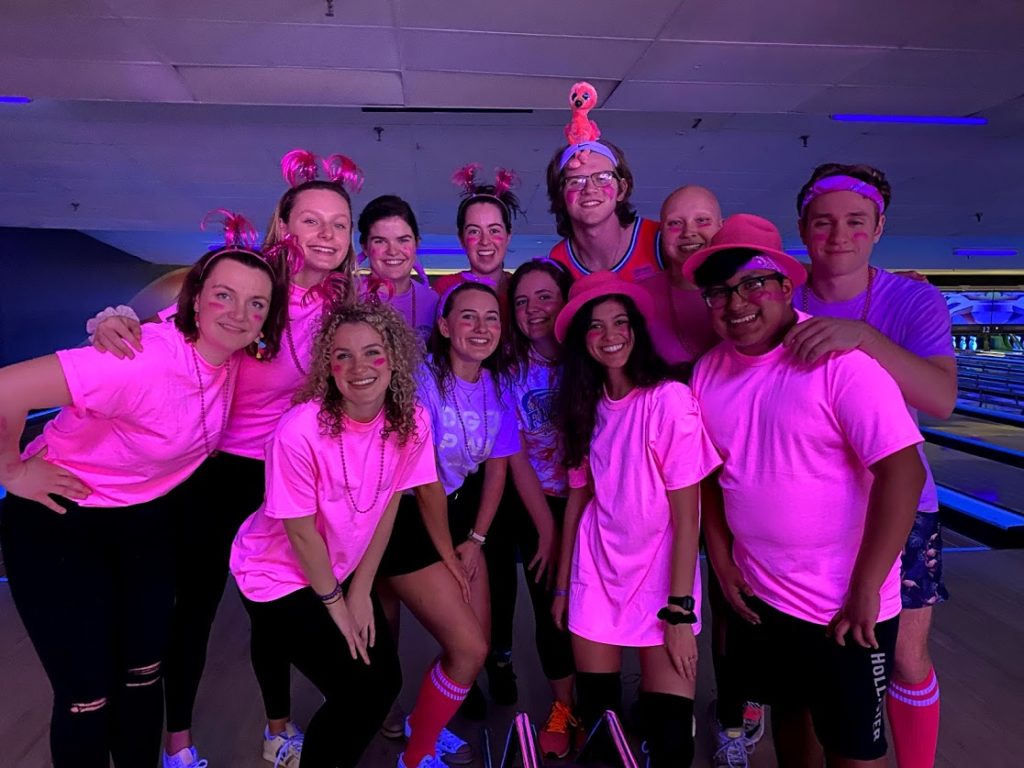 Group of 12 Holy Cross students dressed in pink at Spring Break Immersion Program bowling night